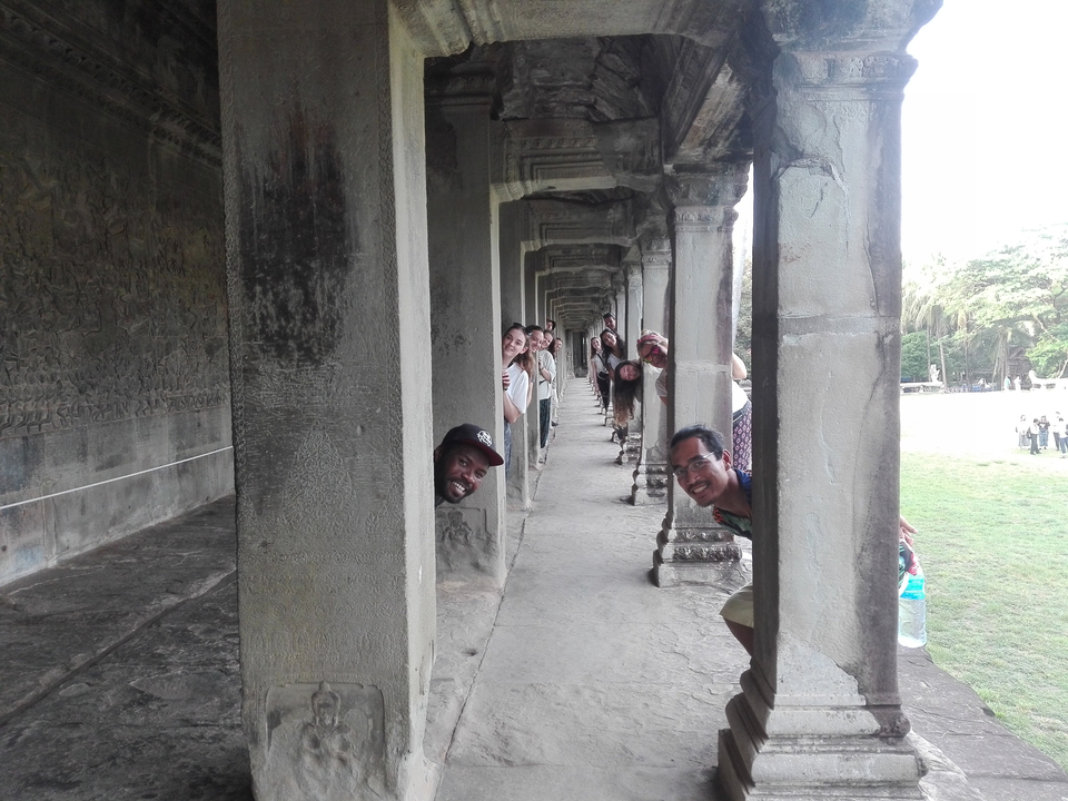 Groupe jouant à cache-cache derrière les piliers d'un ancien temple.