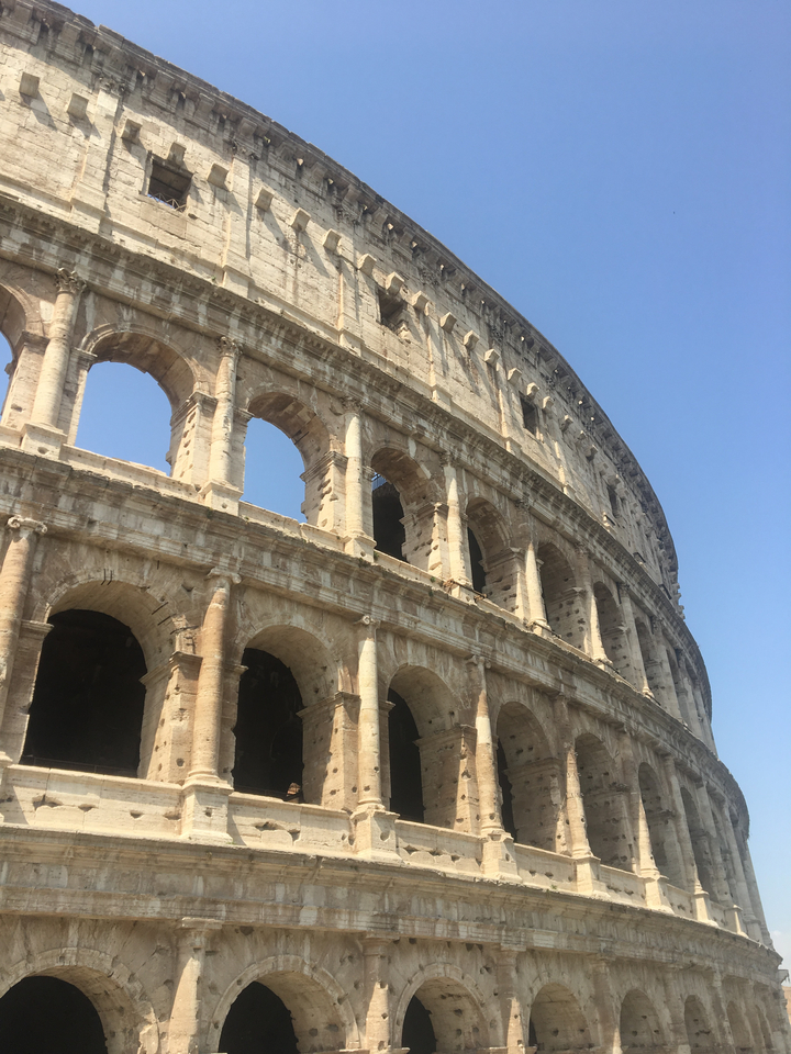 Gros plan du Colisée sous un ciel bleu clair.