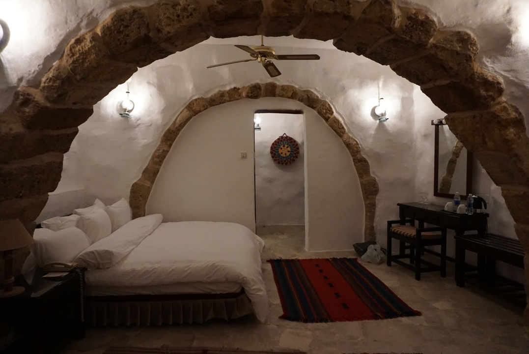 Chambre confortable avec arche en pierre et équipements modernes.