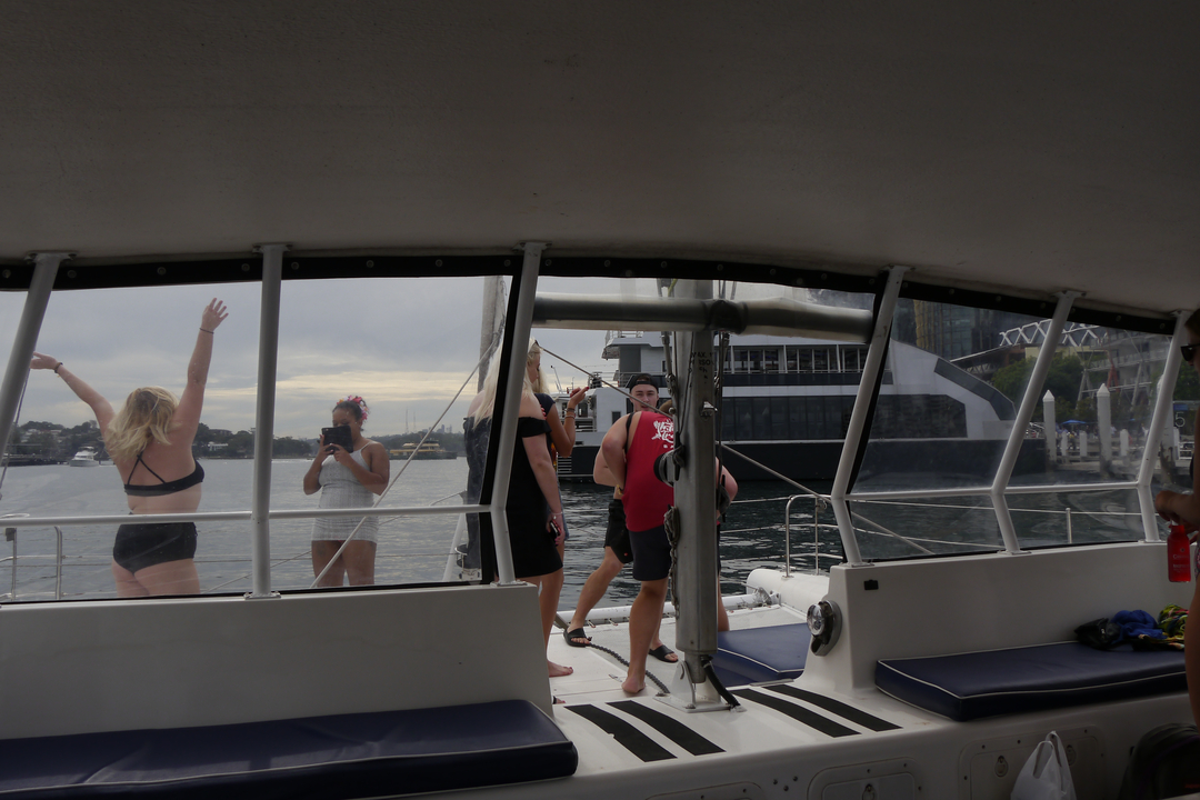 Group enjoying on a boat with scenic harbor view.