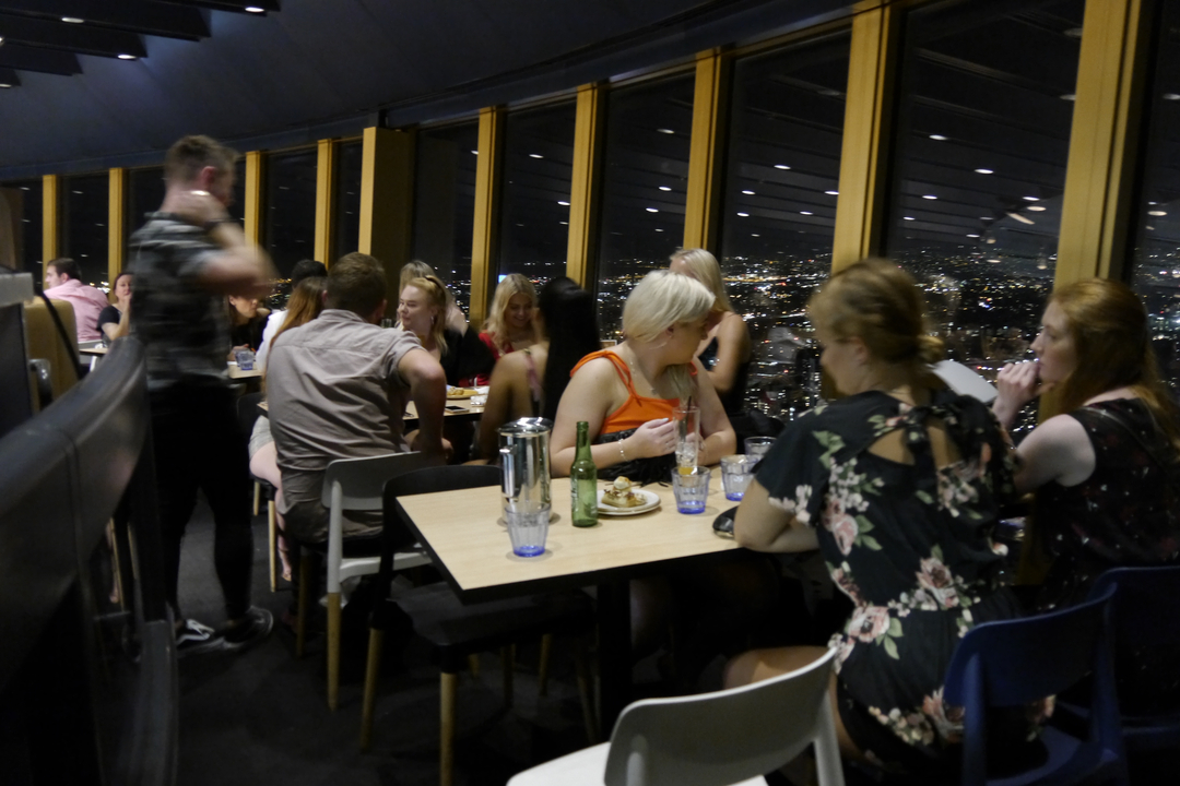 Indoor restaurant scene with people dining at night.