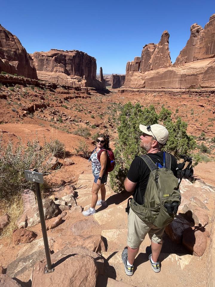 Randonneurs sur un sentier dans un paysage désertique.