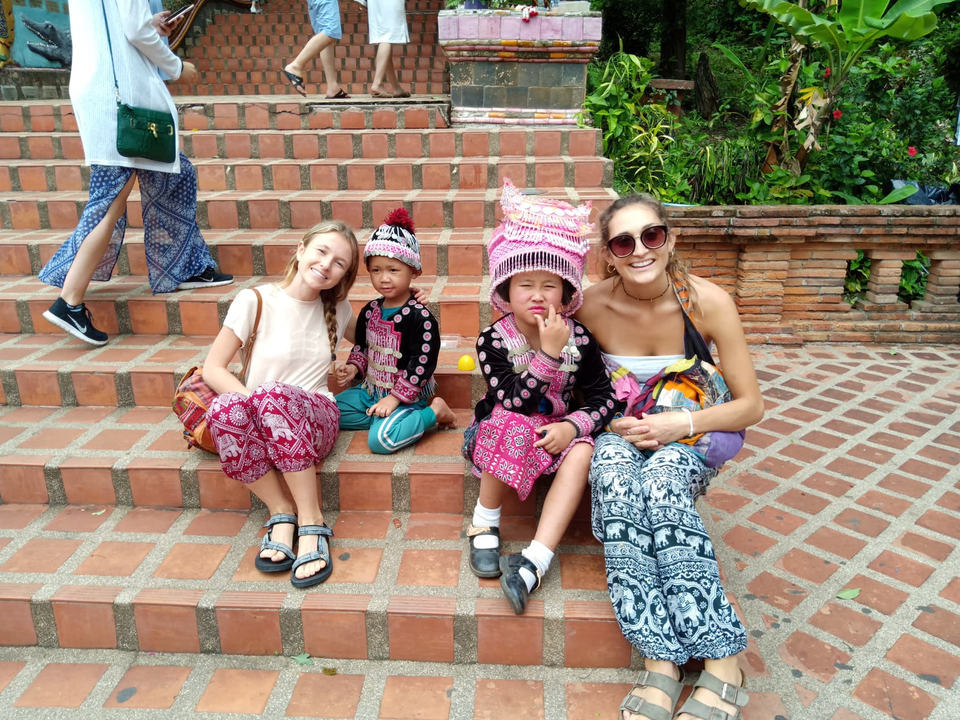 Tourists posing with local children in traditional attire.