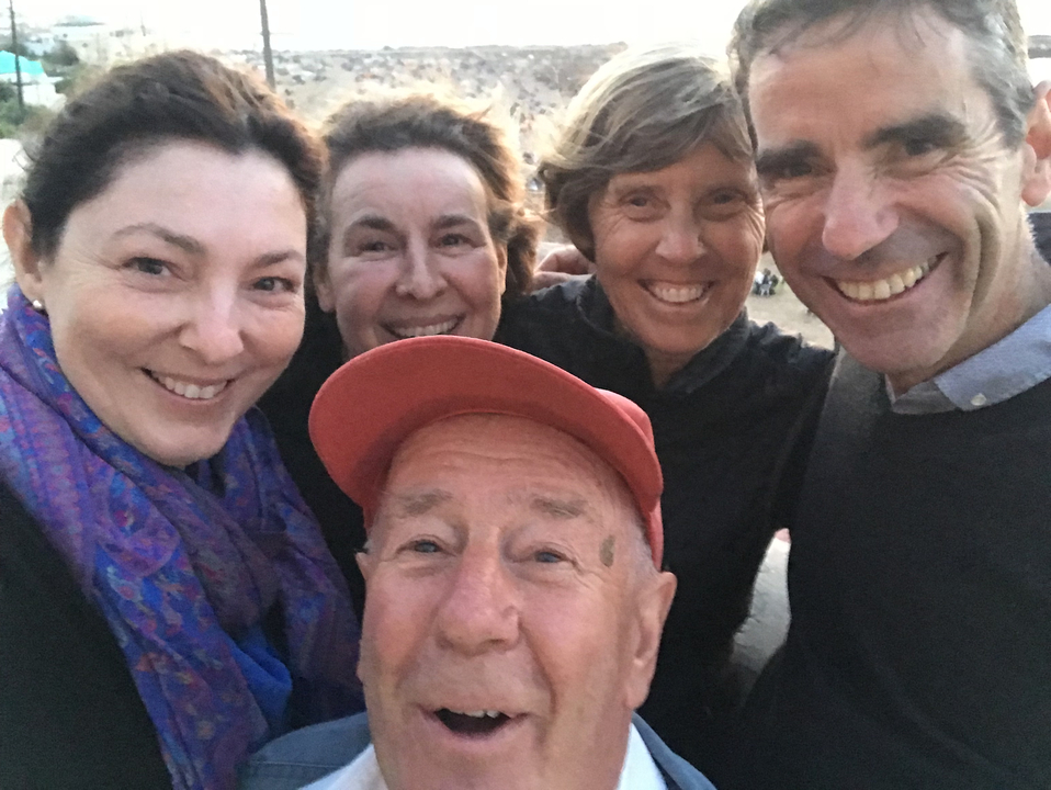 Groupe de personnes prenant un selfie au coucher du soleil.