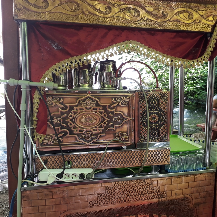 Machine à café complexe au design orné sous un auvent.