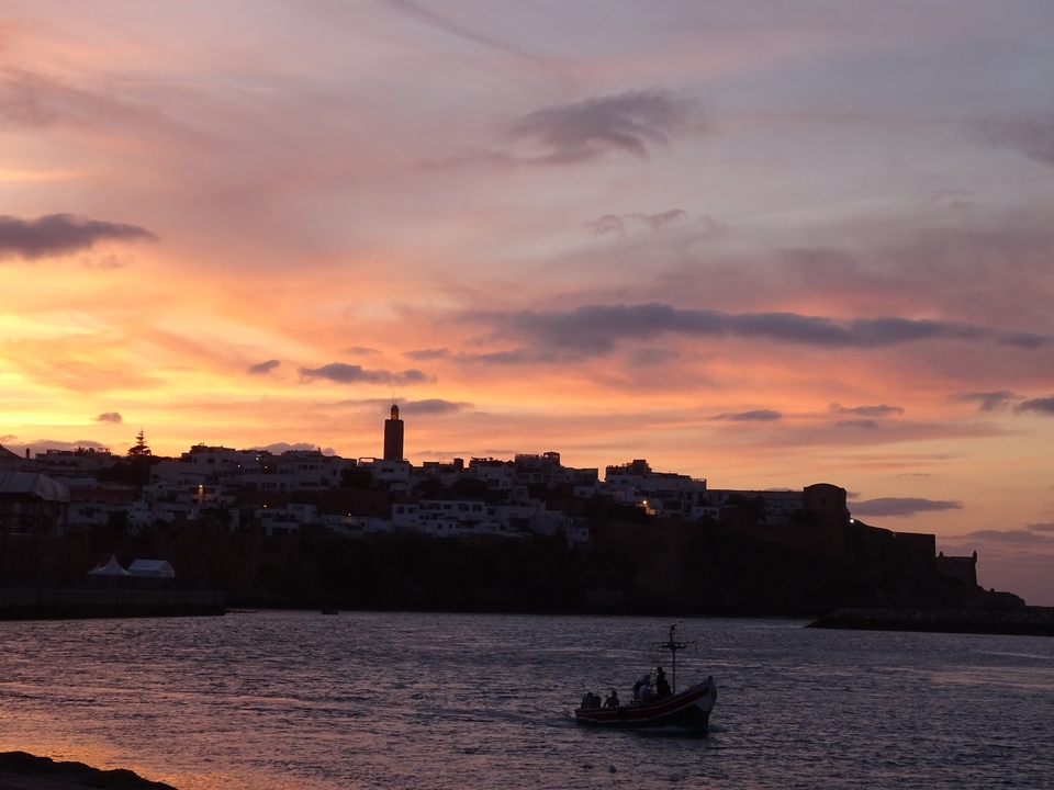 Paysage urbain au coucher du soleil avec un ciel coloré et de vieilles fortifications.