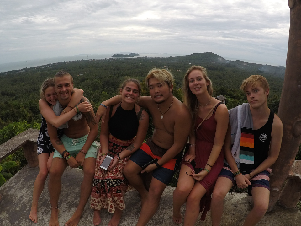 Groupe d'amis sur un point de vue surplombant un paysage côtier.