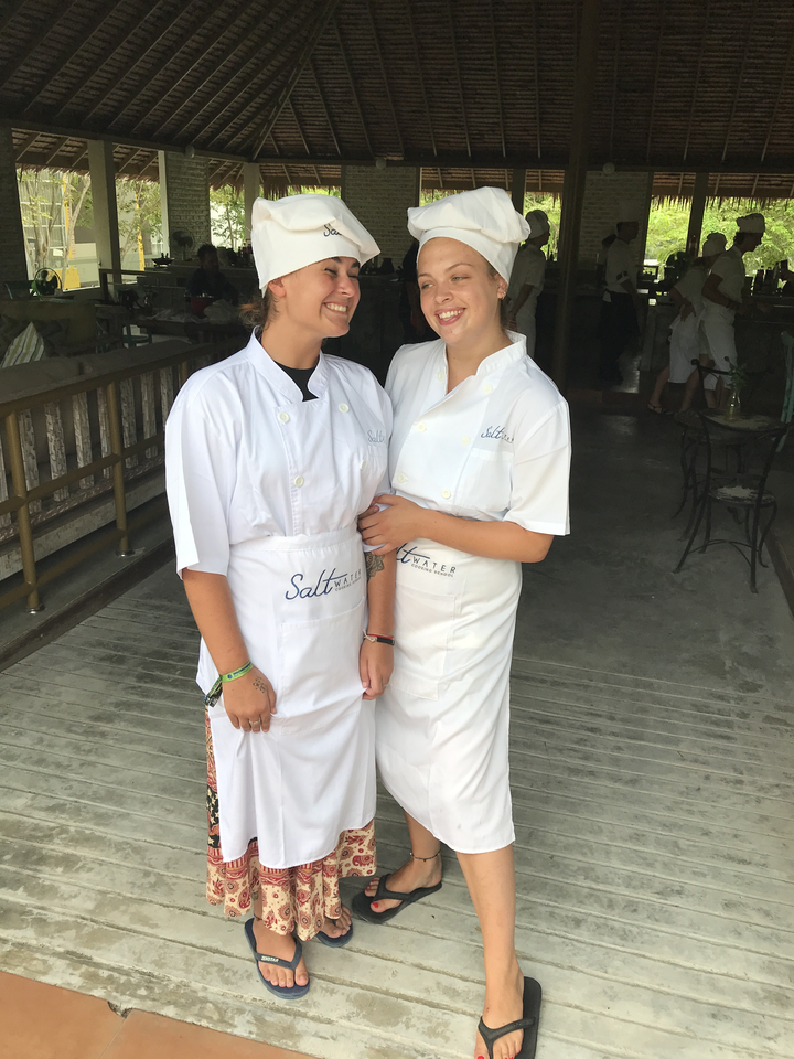 Deux personnes en uniforme de chef sourient et posent ensemble.