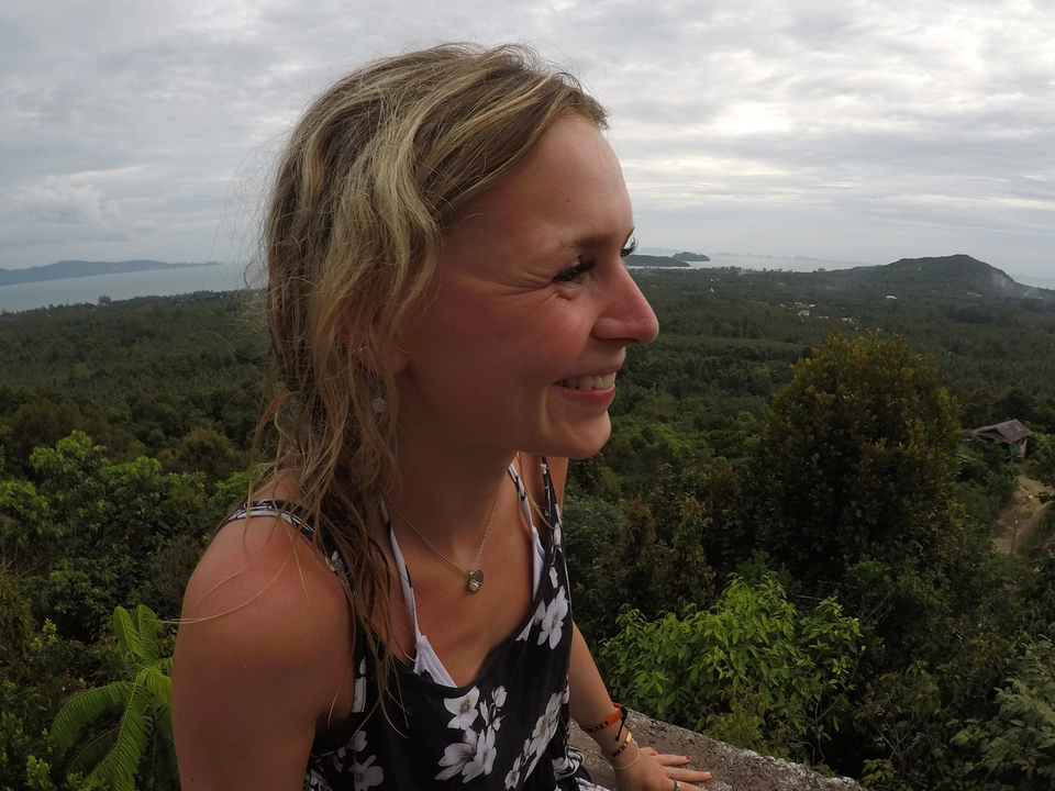 Portrait en gros plan d'une femme souriante avec une vue panoramique en arrière-plan.