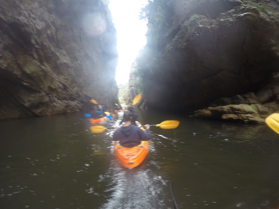 Des personnes font du kayak dans une gorge étroite.
