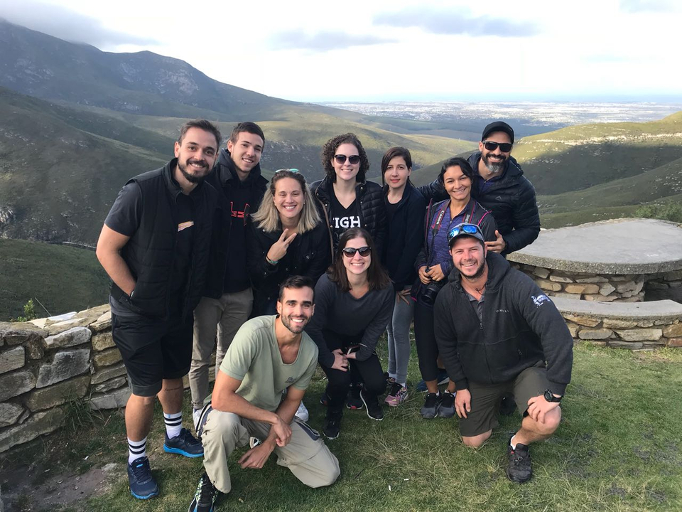 Groupe de personnes posant avec une vue panoramique de la montagne.