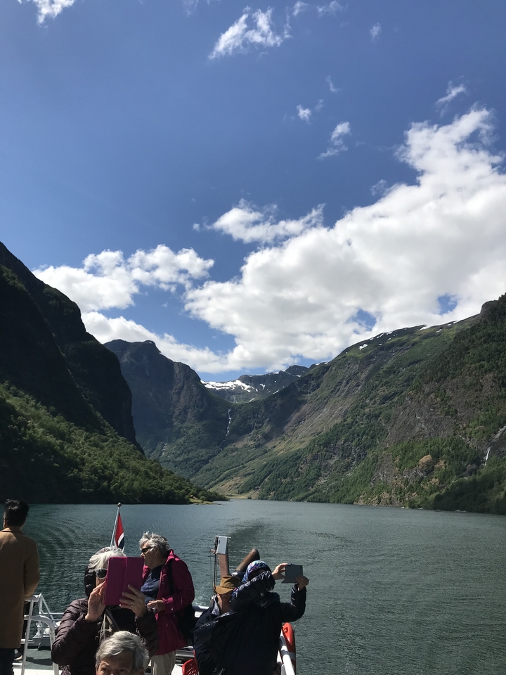 Vue d'une vallée montagneuse dans un ciel partiellement nuageux.