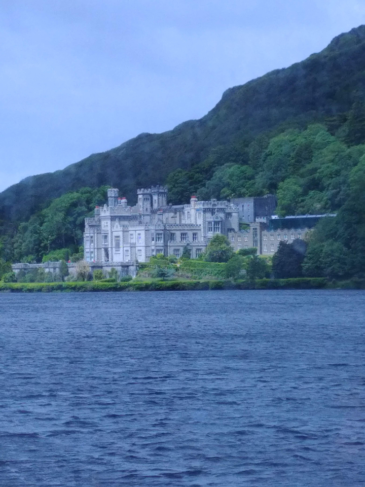 Château au bord d'un lac avec une végétation luxuriante.