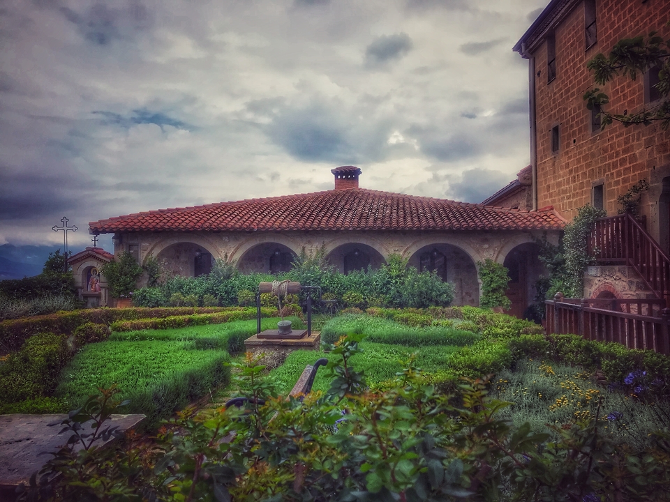 Bâtiment historique avec un jardin au premier plan.