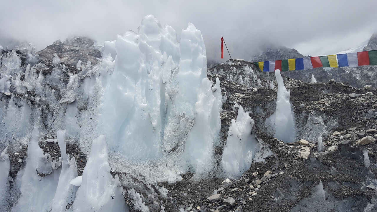 Des drapeaux de glace et de prière dans un paysage accidenté et enneigé.