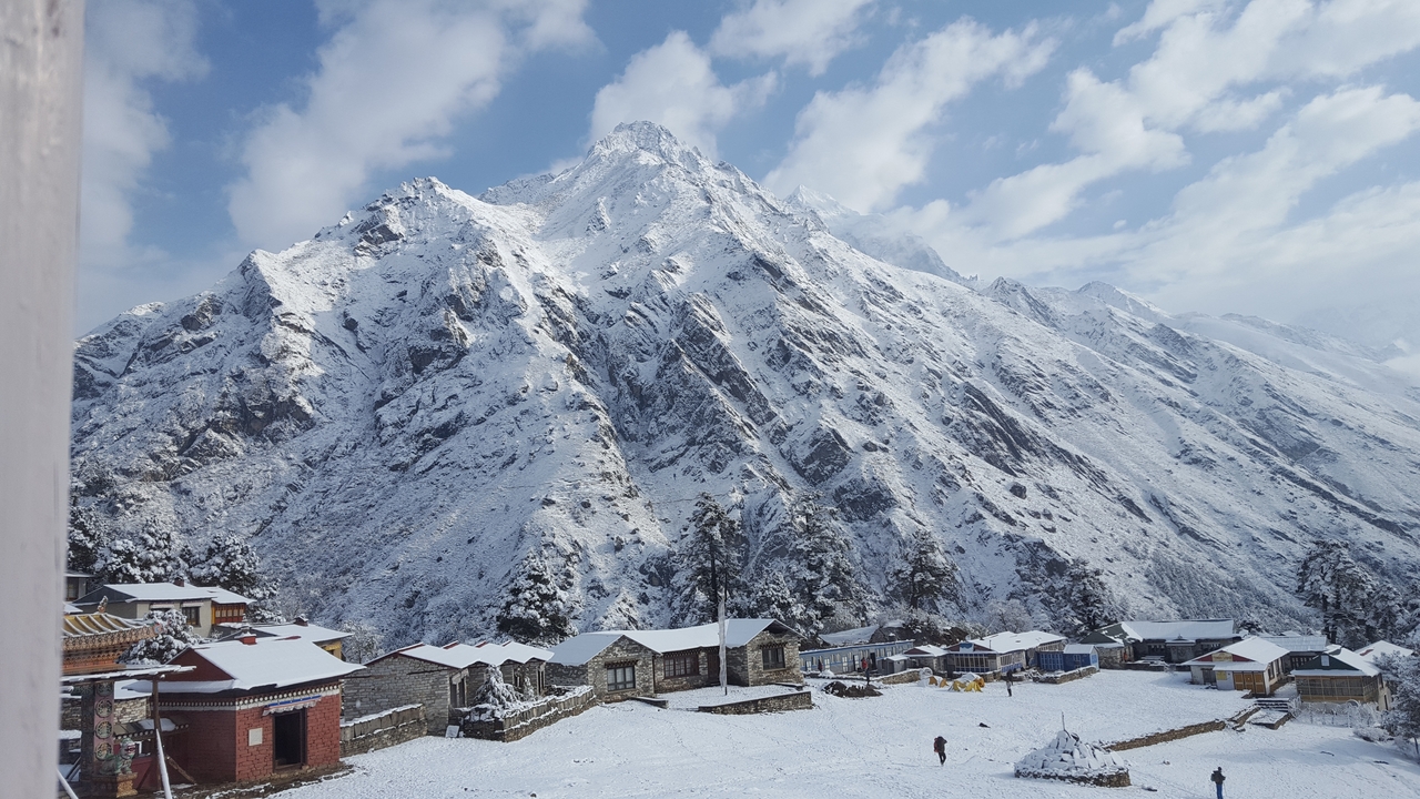 Des montagnes enneigées avec un village dans la vallée en contrebas.