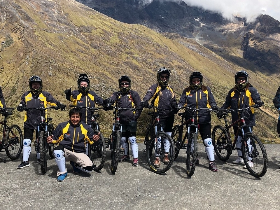 Groupe de cyclistes posant avec leurs vélos sur une route de montagne