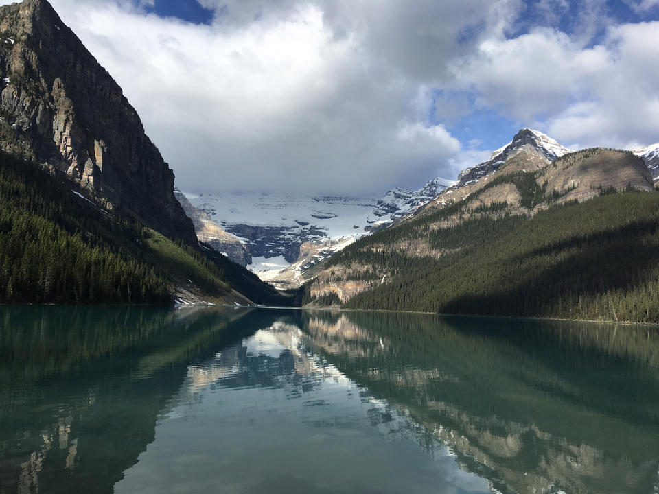 Lac serein avec montagnes enneigées et ciel nuageux