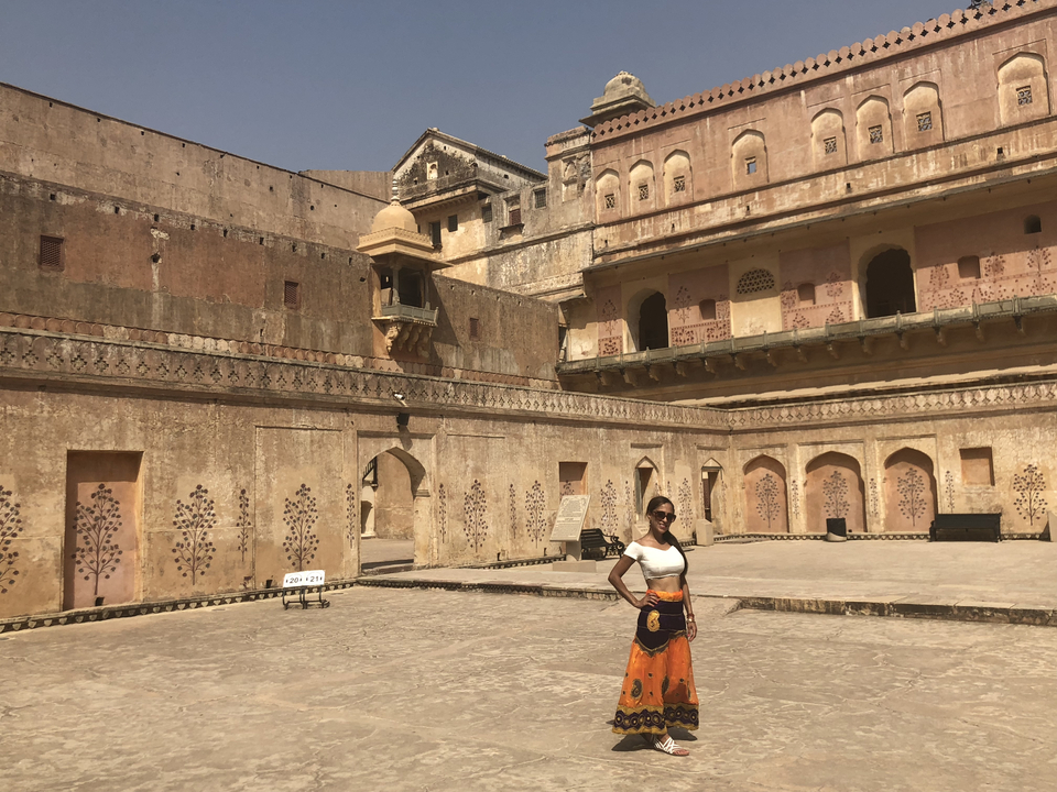 Femme posant en plein air dans une cour historique.