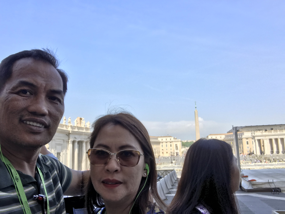 Couple posing with a view of an iconic square and obelisk.