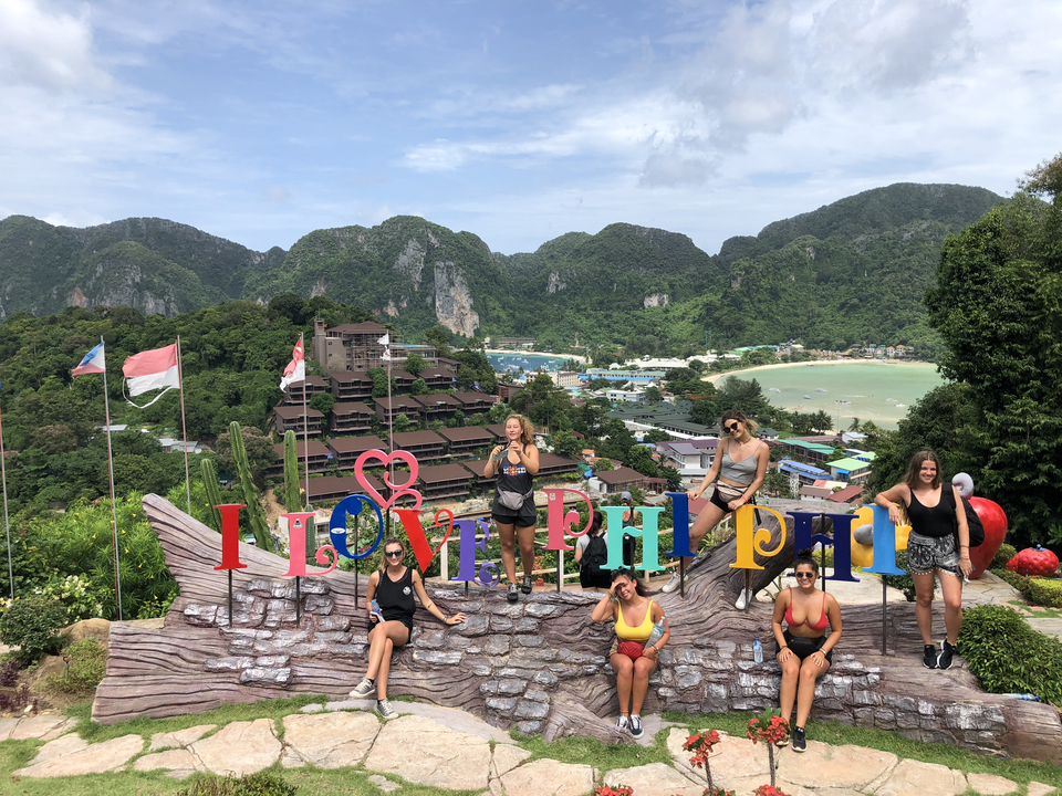Group of women posing with 'I Love Phi Phi' sign.
