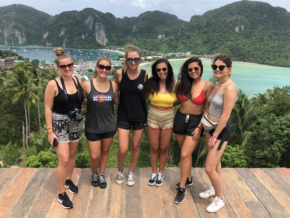 Group of friends posing with a scenic island background.