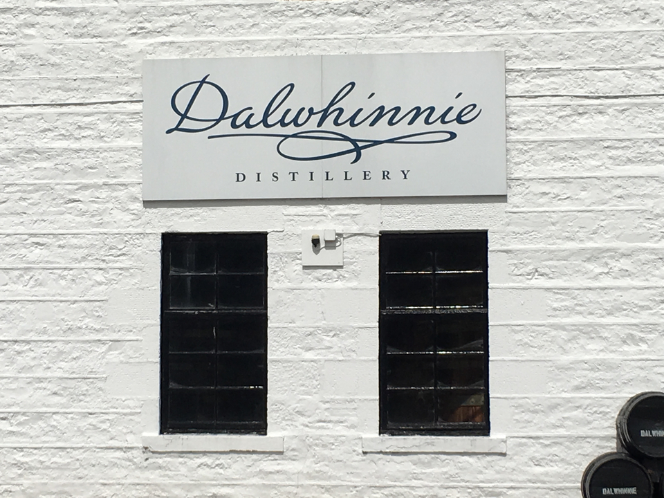 Dalwhinnie Distillery sign on a white building.