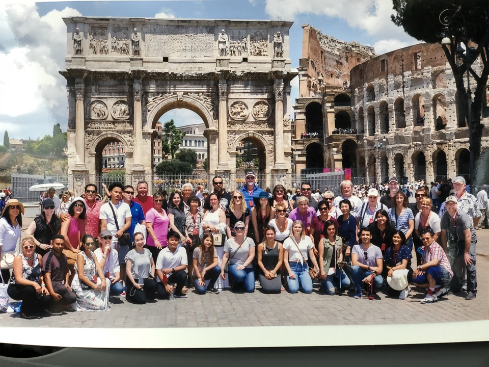 Un grand groupe de personnes posant devant des ruines historiques.