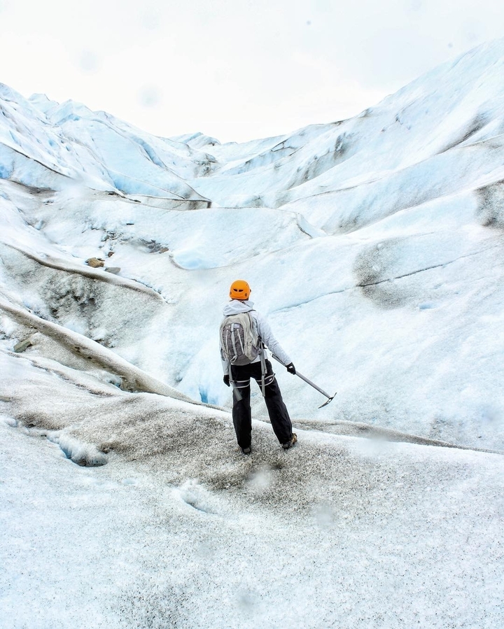 Personne avec un piolet sur un glacier.