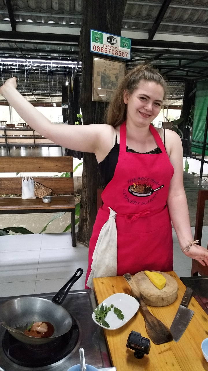Person wearing a pink apron during a cooking class.