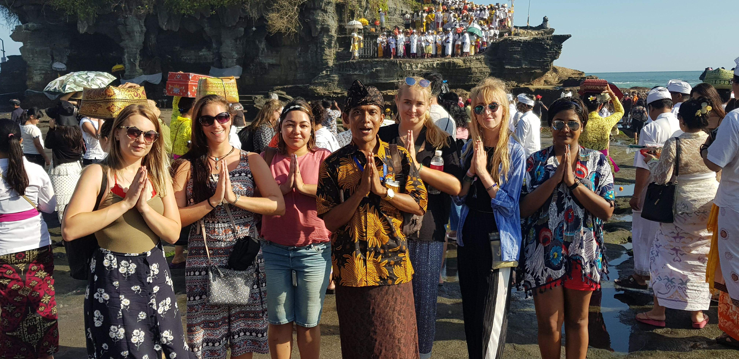 Group of people posing at a cultural site with traditional attire.
