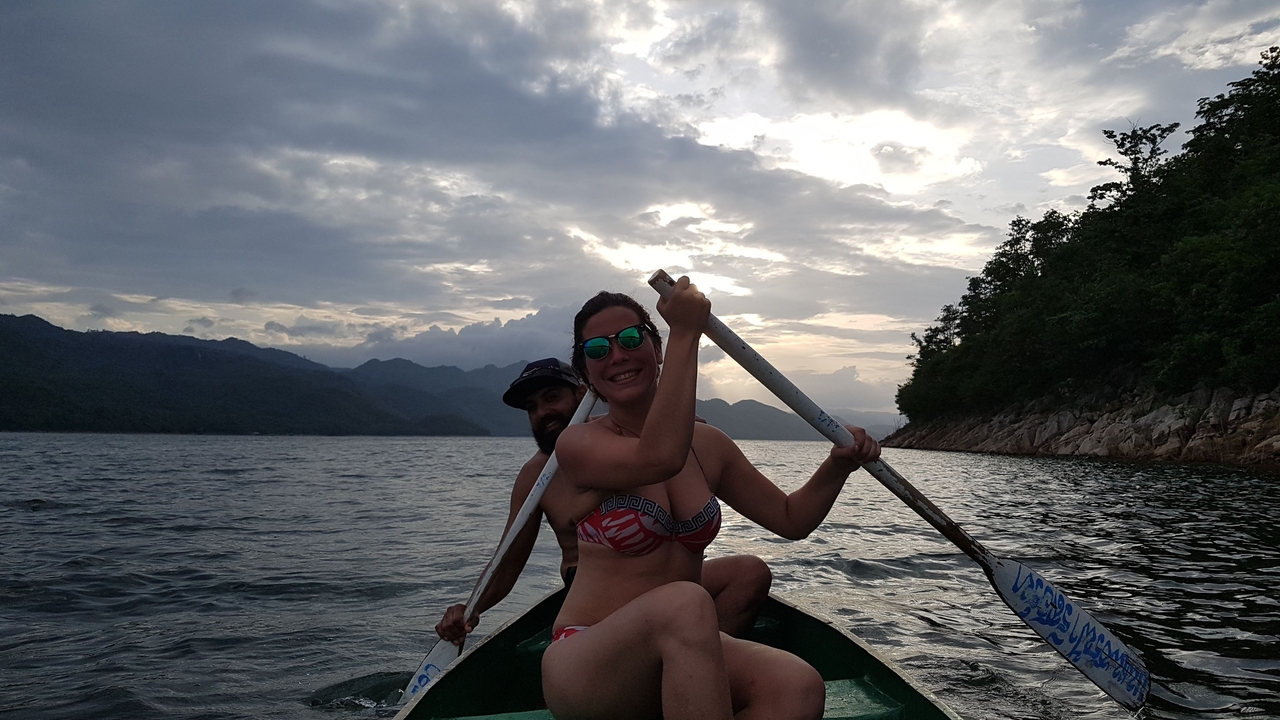 Deux personnes pagayant dans un petit bateau sur un lac serein.