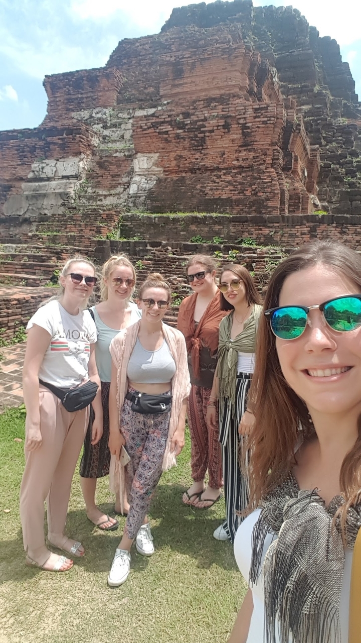 Groupe de personnes posant devant des ruines anciennes.