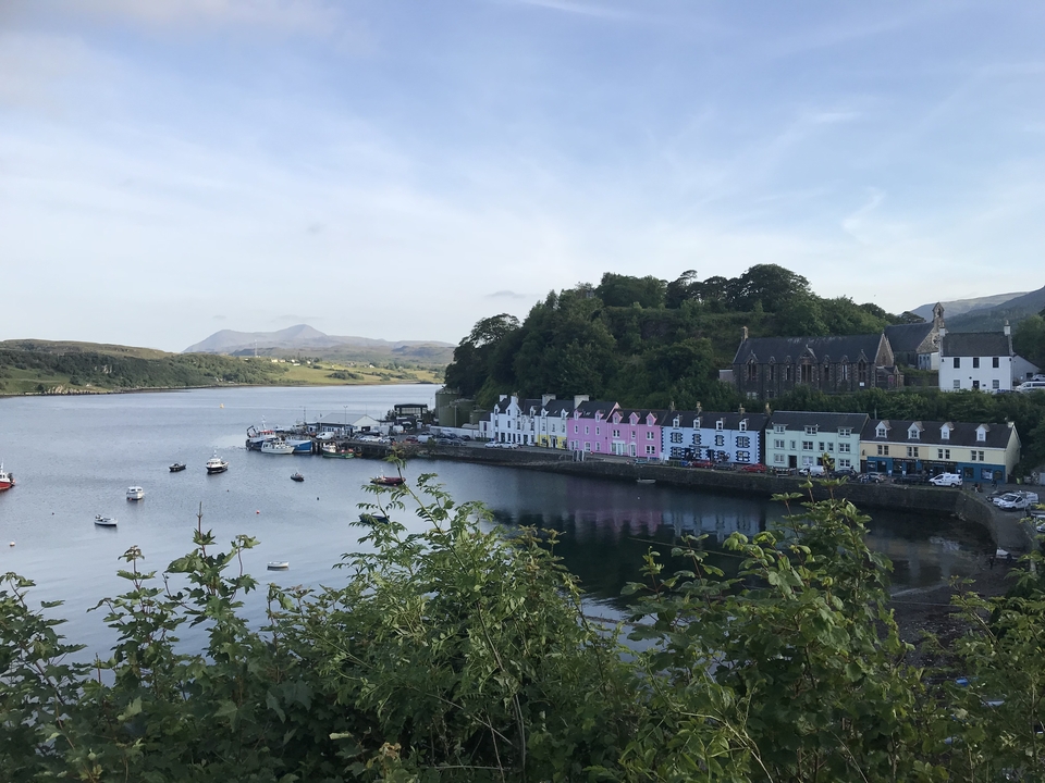 Maisons colorées au bord de l'eau avec des collines.
