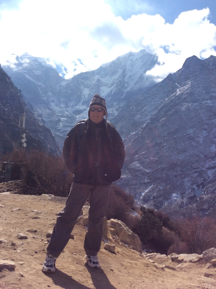 Randonneur en tenue d'hiver dans une région montagneuse et enneigée.