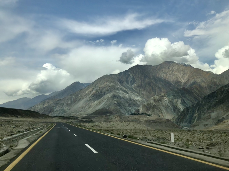 Highway road leading through barren mountainous terrain.