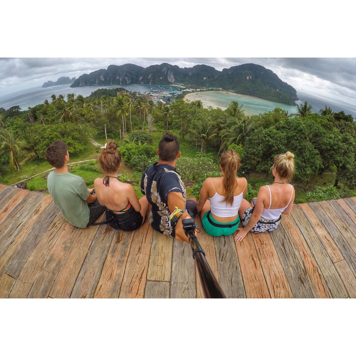 Group of people sitting on a deck overlooking a bay with a view.