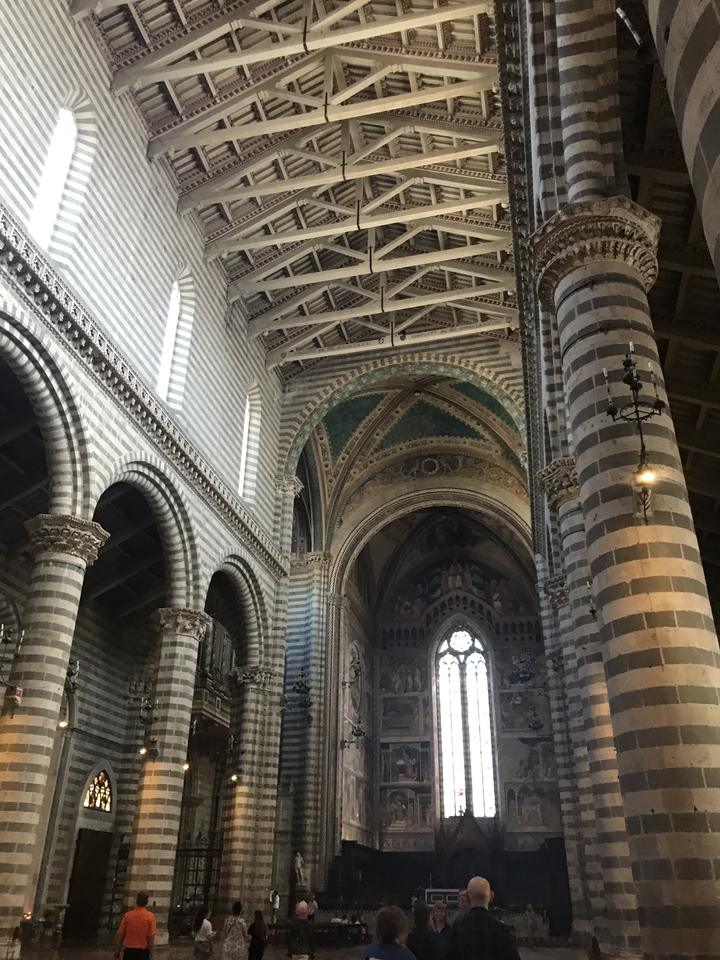 Intérieur de la cathédrale d'Orvieto avec des colonnes rayées.