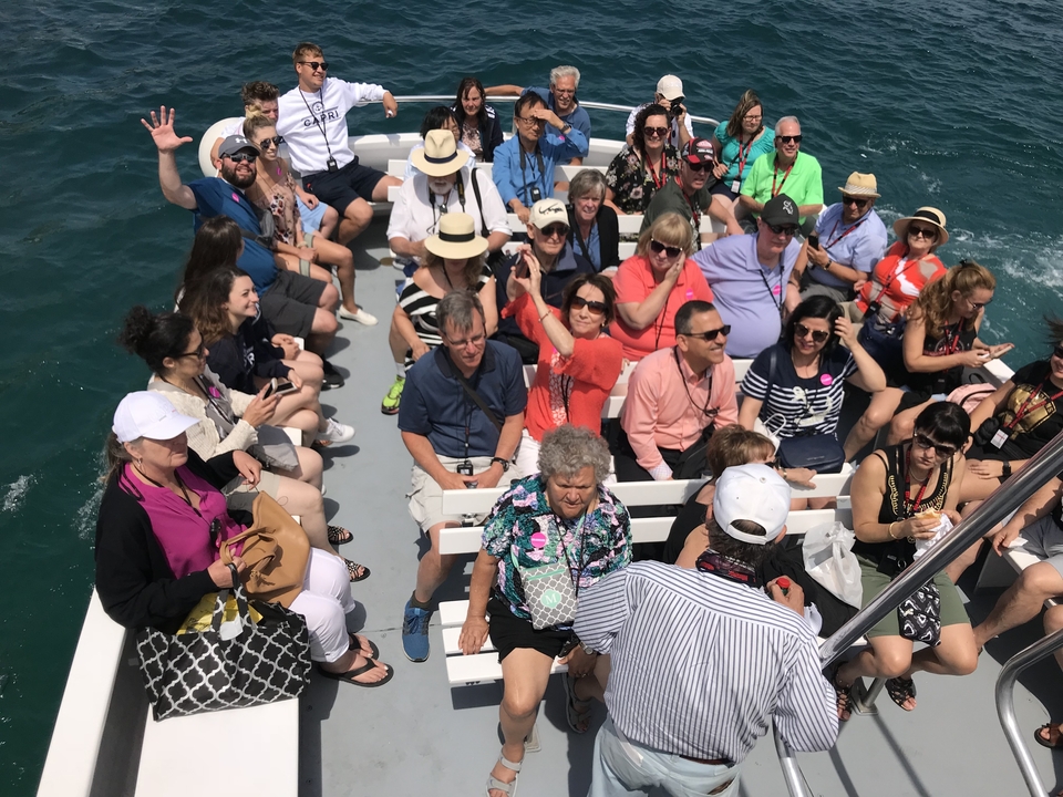 Groupe de touristes sur un bateau aux eaux bleues.