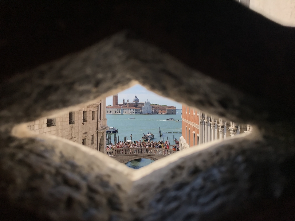 Vue emblématique d'un port animé à travers une fenêtre en pierre.