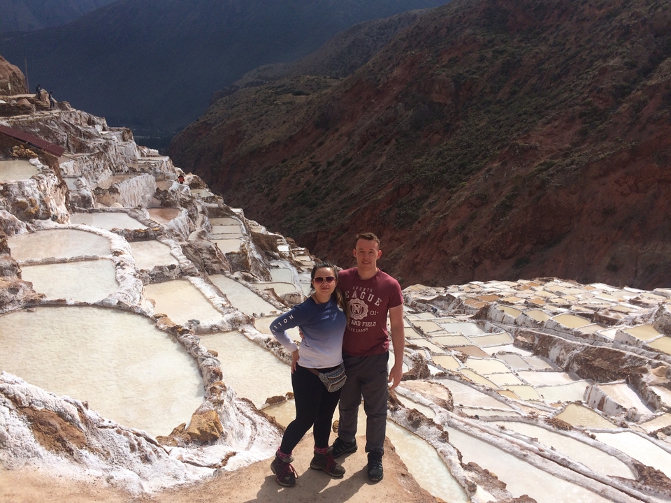 Touristes dans les mines de sel avec des étangs en terrasses.