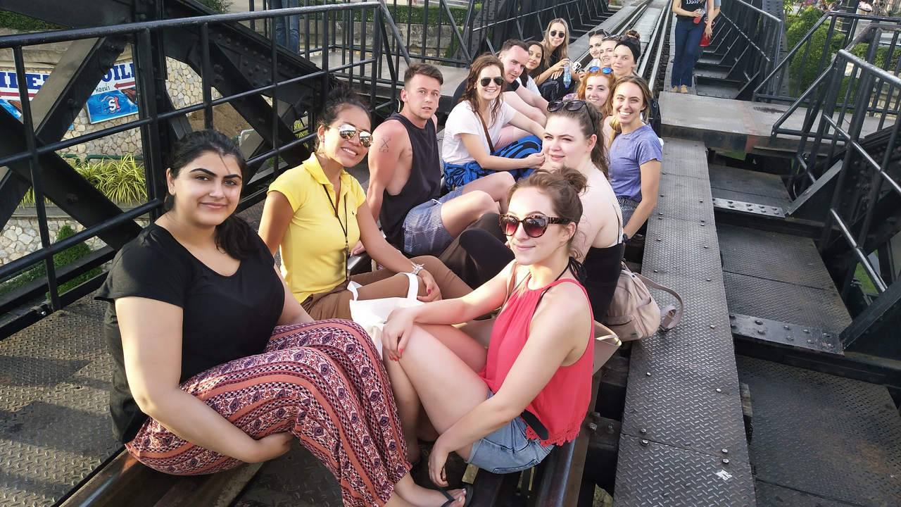 A group of people sitting on a bridge.
