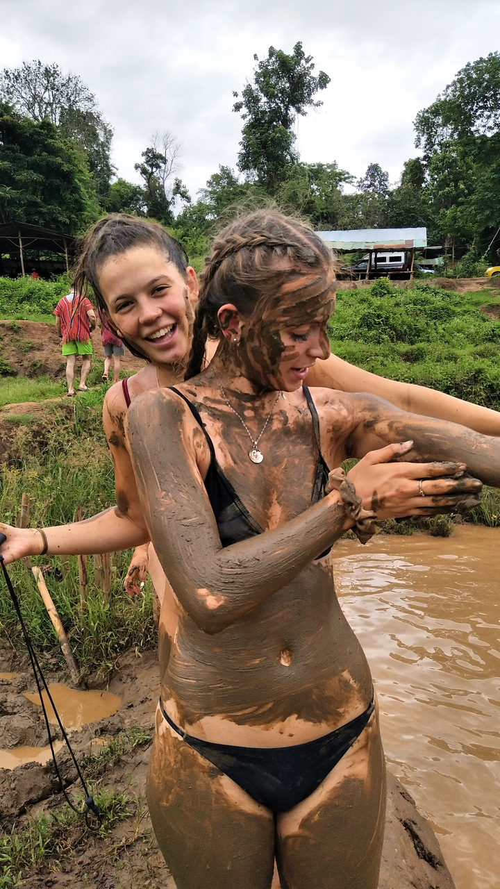 Close-up of muddy people enjoying an activity.