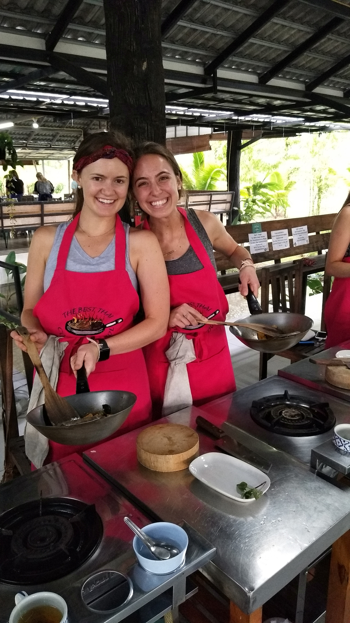 Cooking class with people holding frying pans.