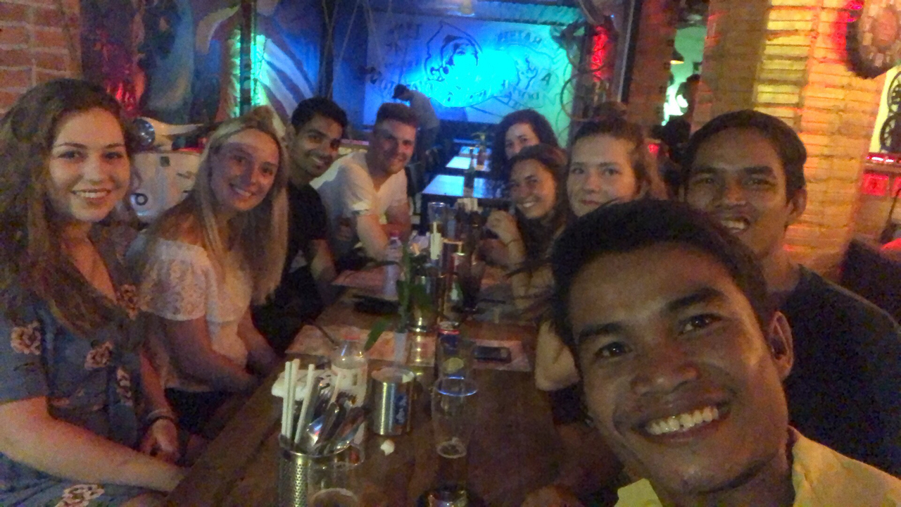 Groupe de personnes dans un bar au décor coloré.