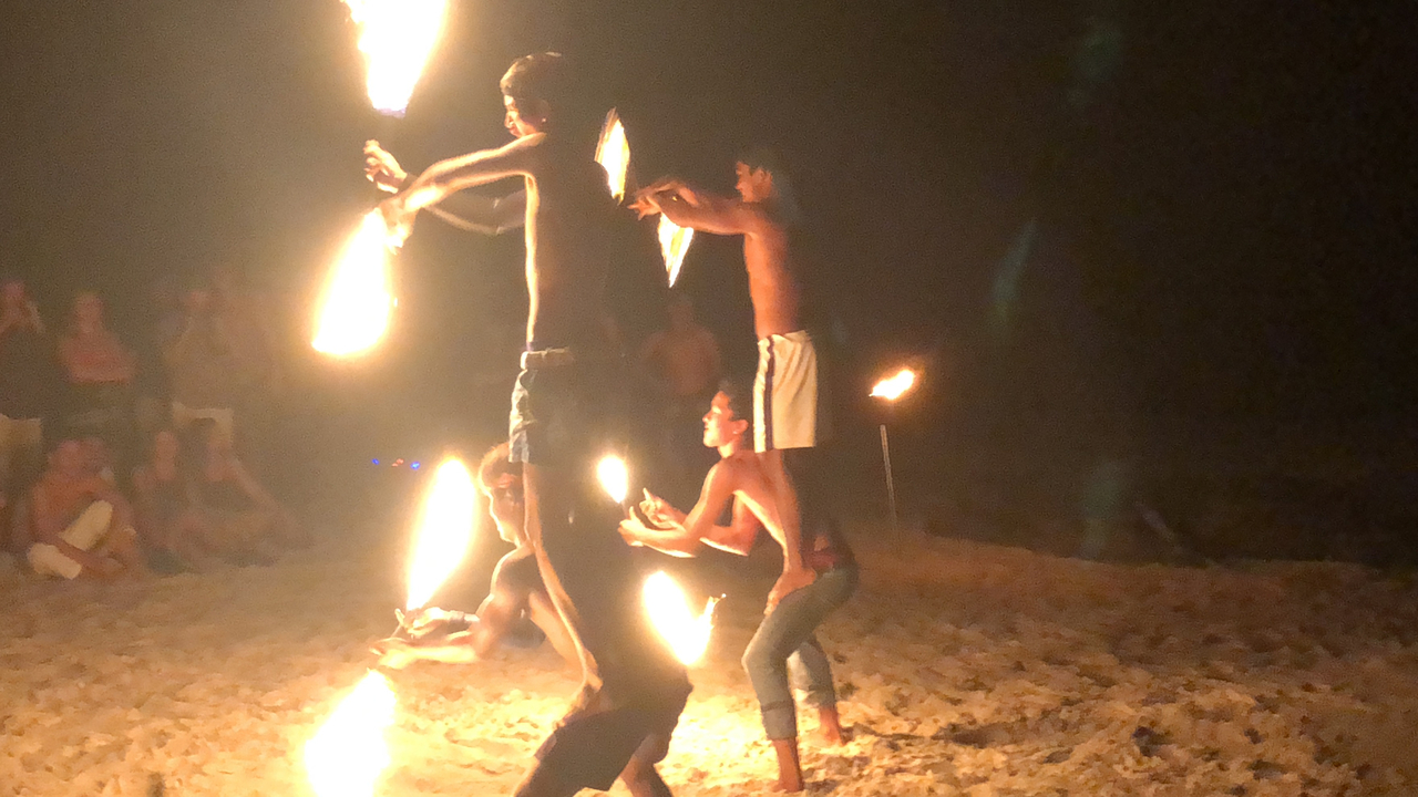 Artistes de feu sur une plage la nuit.