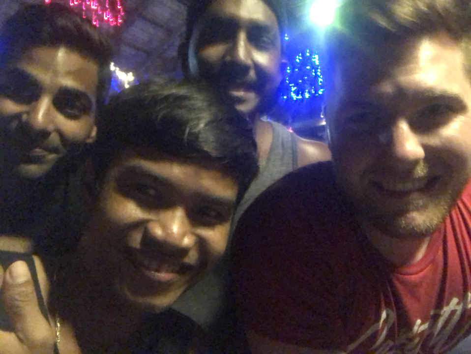 Gros plan sur plusieurs personnes souriantes lors d'un événement nocturne.