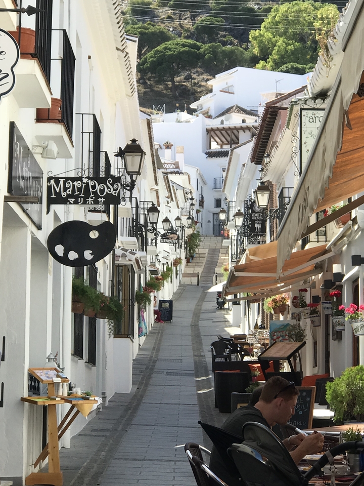 Charmante rue étroite bordée de bâtiments blancs et de boutiques.