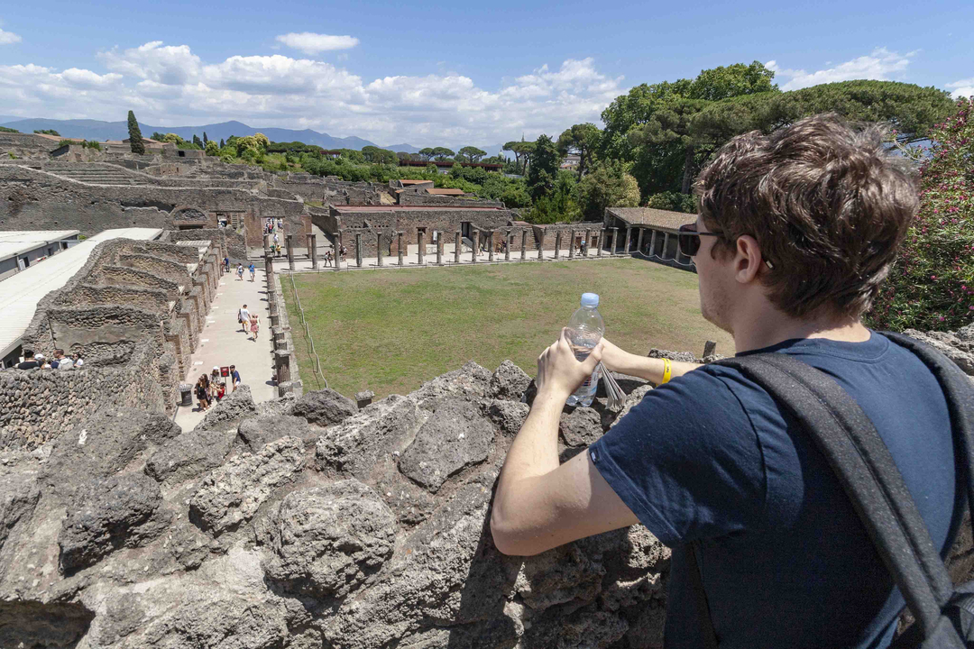 Personne observant des ruines anciennes depuis une hauteur.