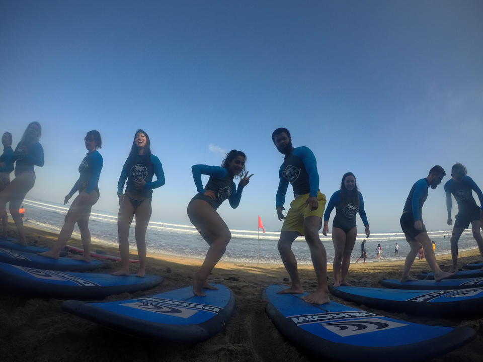 Group of surfers on the beach, slightly blurry.
